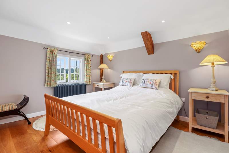 The main bedroom has a lovely king-size bed and views of the garden and countryside.