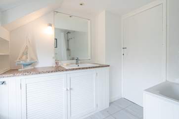 The bathroom with bath and shower over.