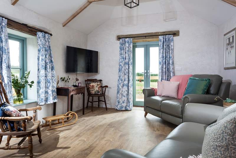 The comfortable sitting-room with views looking over the surrounding fields.