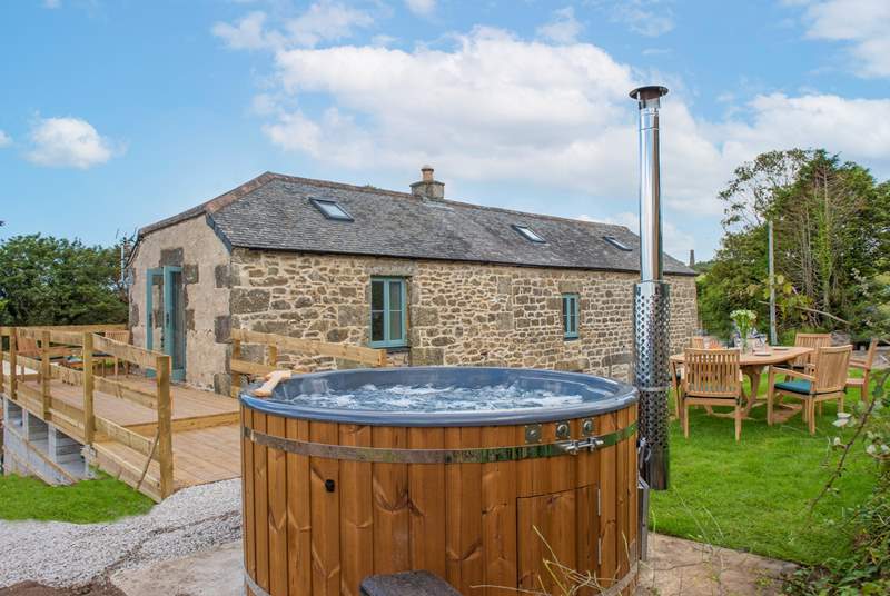 The wonderful wood-fired hot tub makes the most of the views.