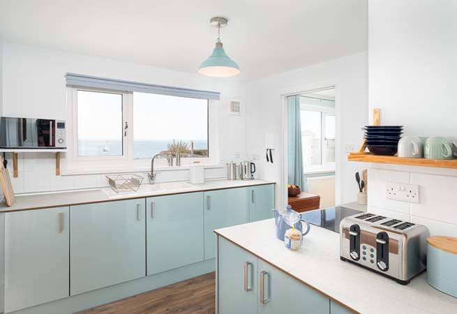 The gorgeous kitchen has cool and calming tones, perfect for a house by the sea!