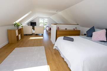 The open plan bedroom with a sumptuous king-size bed and a 'zip and link' bed (can be a double or twin beds, you choose!), perfect for families!