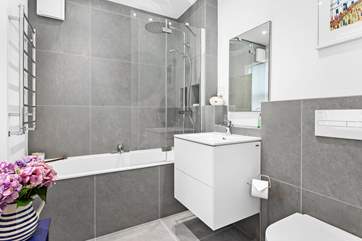The main bathroom on the ground floor has a waterfall shower over the bath.
