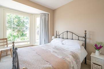 The pretty main bedroom is furnished with an ornate, comfy double bed.