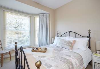 The pretty main bedroom is furnished with an ornate, comfy double bed.