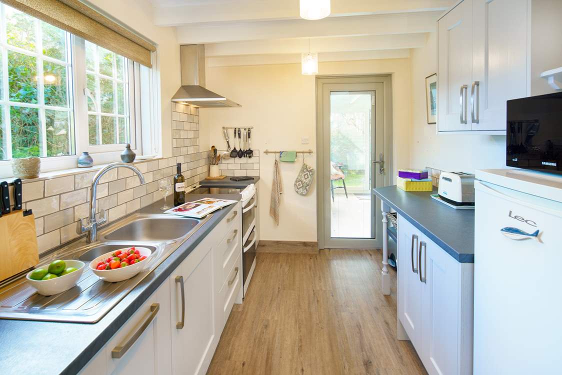 The light and airy kitchen leads out to the garden-room.