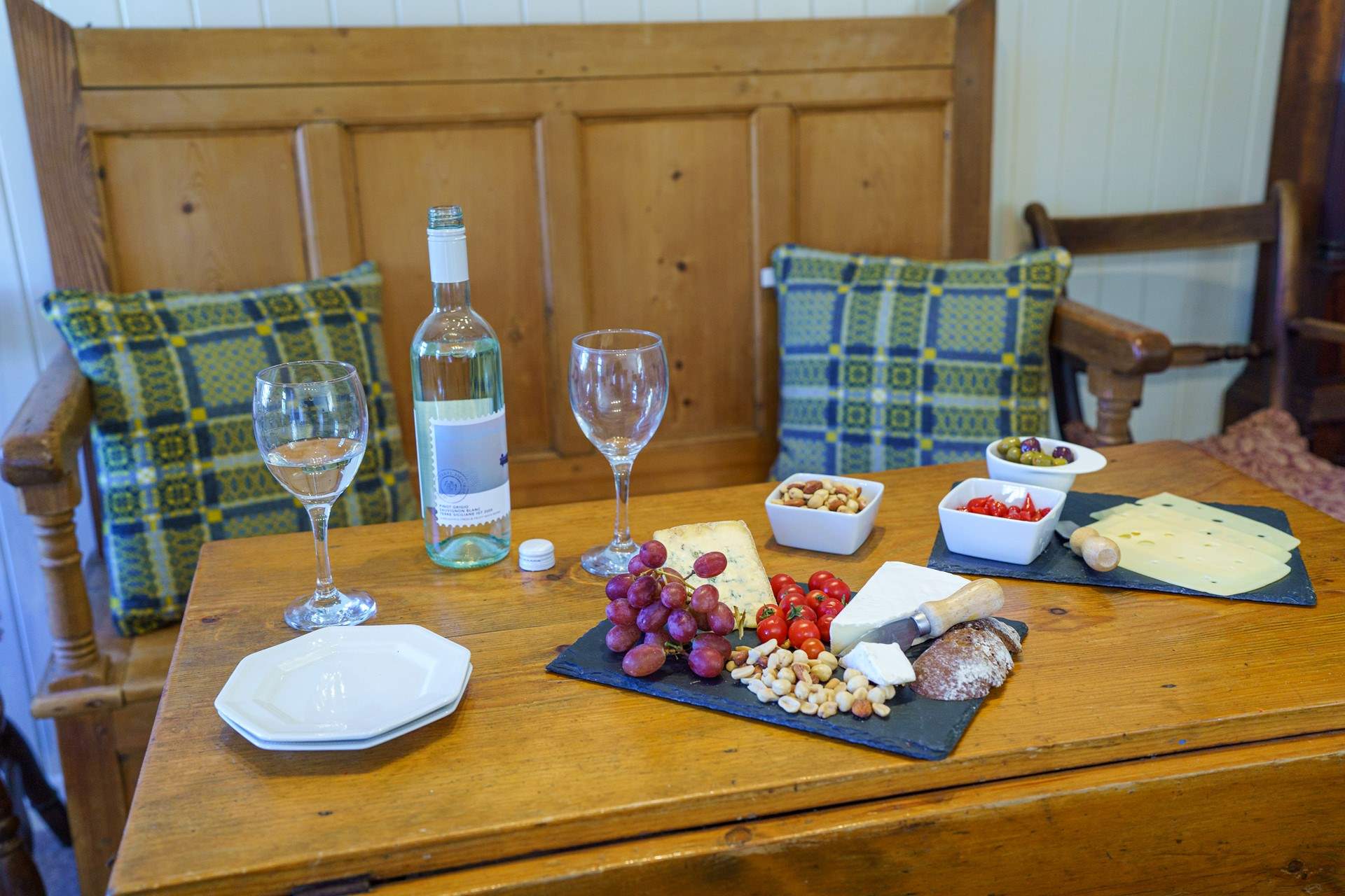 Sweet dining area decked with Welsh wool cushions. Dine in the glow of the cosy wood-burner. 