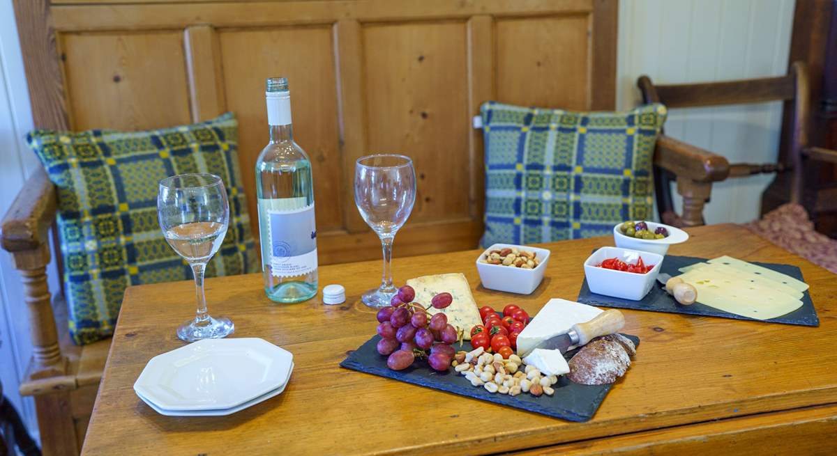 Sweet dining area decked with Welsh wool cushions. Dine in the glow of the cosy wood burner. 
