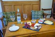Sweet dining area decked with Welsh wool cushions. Dine in the glow of the cosy wood-burner.