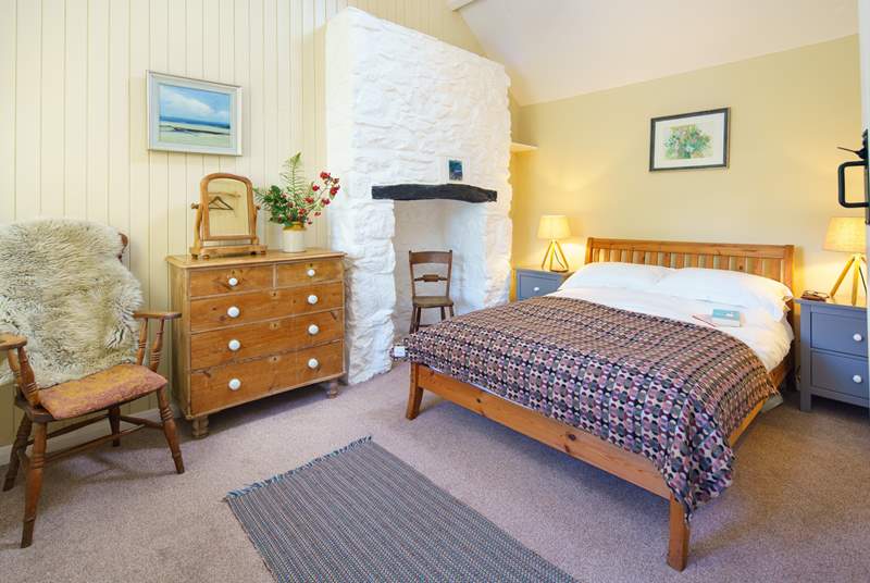 The charming double bedroom has a feature inglenook fireplace and exposed beams.