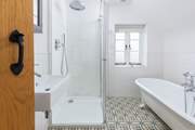 A large shower and roll-top bath make for a luxurious bathroom.
