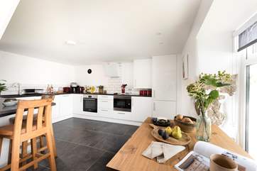 A choice of places to eat, perched at the breakfast-bar or around the dining-table.