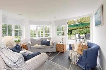 The comfortable sofas looking out to the garden and the garden table.