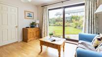Step out of the snug area onto the beautiful patio and garden area beyond.