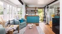 To the right, you can see the fridge and microwave. The kettle and coffee machine are also positioned here. The plug-in double hob is tucked away in the kitchen cupboards. 