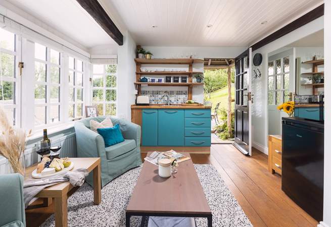 To the right, you can see the fridge and microwave. The kettle and coffee machine are also positioned here. The plug-in double hob is tucked away in the kitchen cupboards. 