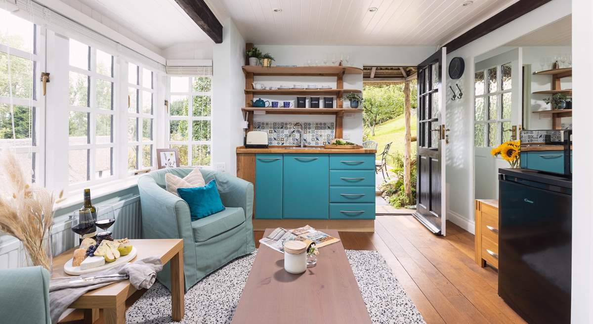 To the right, you can see the fridge and microwave. The kettle and coffee machine are also positioned here. The plug-in double hob is tucked away in the kitchen cupboards. 