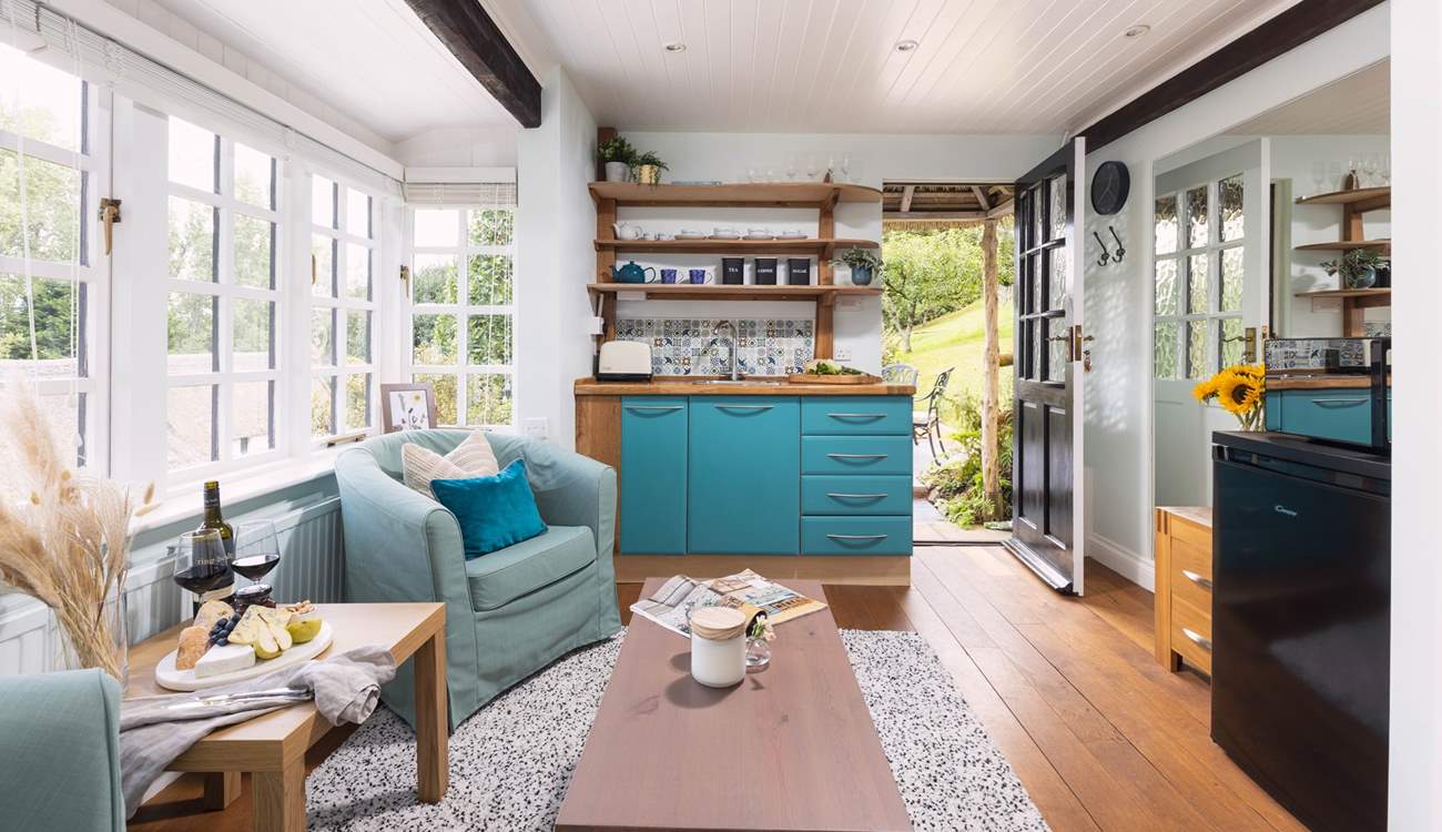 To the right, you can see the fridge and microwave. The kettle and coffee machine are also positioned here. The plug-in double hob is tucked away in the kitchen cupboards. 
