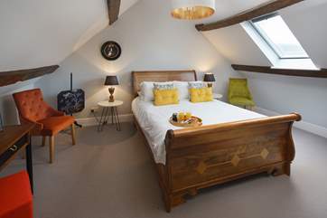 The main bedroom with original beams and sloping ceilings, giving this room lots of character with views overlooking the clock tower.