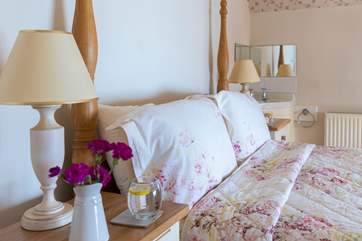 The main bedroom has pretty floral linen, lie in bed and gaze out to sea.