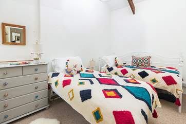 The cheerful twin bedroom has jazzy bed linens.
