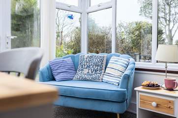 The comfy sofa in the conservatory is the perfect spot for a holiday read.
