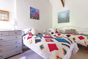 The cheerful twin bedroom has jazzy bed linens.