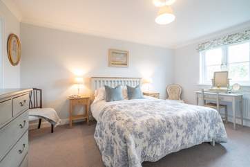 The lovely main bedroom overlooks the garden.
