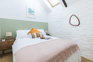 Light filled and beautifully decorated, the double bedroom with characterful beams is charming.