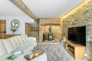 The characterful sitting/dining-room has a gorgeous wood-burner and original exposed beams.