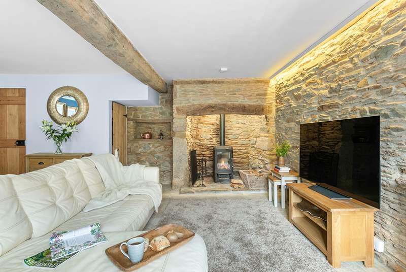 The characterful sitting/dining-room has a gorgeous wood-burner and original exposed beams.
