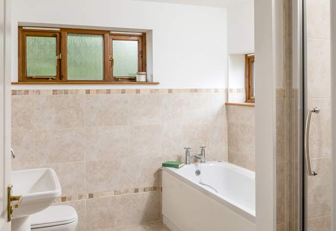 The family bathroom has a large bath for two and a separate shower. 