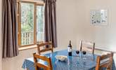 The dining-table looks out over the decking and trees beyond where you might spot a wren or robin perhaps.  - Thumbnail Image