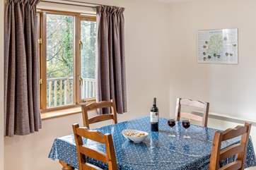 The dining-table looks out over the decking and trees beyond where you might spot a wren or robin perhaps.