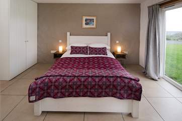 The double bedroom on the upper ground floor has patio doors out onto the lawn.