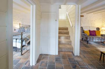 Bedroom one on the ground floor and the staircase leading up to the other bedrooms.
