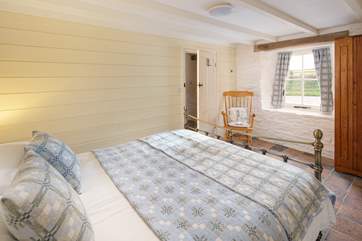 Bedroom one has a king-size bed with a view looking out across the countryside.
