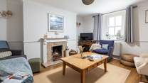 The cosy sitting-room is warmed by an open fire.