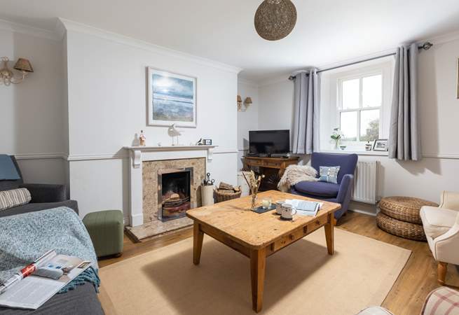 The cosy sitting-room is warmed by an open fire.