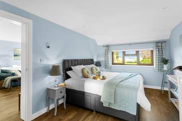 The delightful bedroom has lovely views over the countryside.