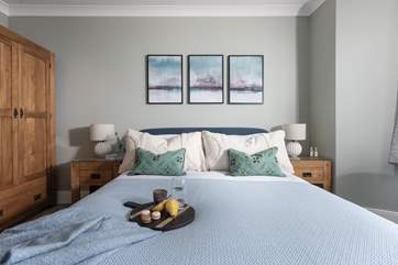 Lovely linens. plump cushions and a gorgeous throw adorn the bed.