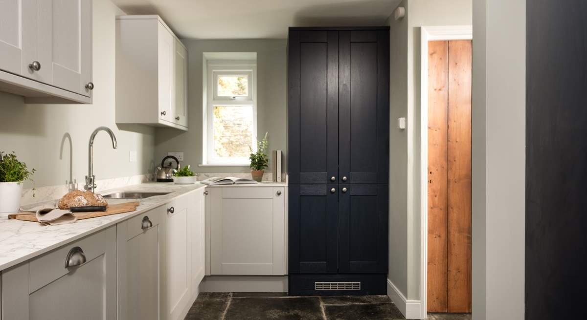 The greys and blues of the modern kitchen blend perfectly with the fabulous flagstone floor.