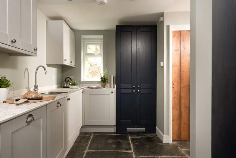 The greys and blues of the modern kitchen blend perfectly with the fabulous flagstone floor.