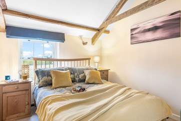 Exposed beams add to the character of the sweet double bedroom.