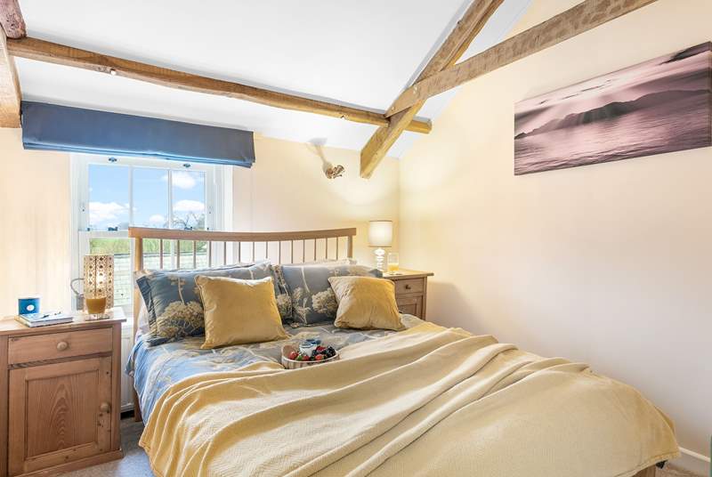 Exposed beams add to the character of the sweet double bedroom.