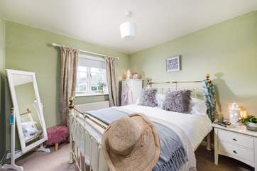 The cosy double bedroom has a wonderful bedstead