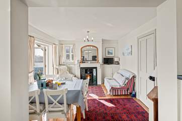The sun floods in through the patio doors into the dining-area.