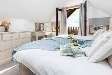 The delightful double bedroom on the first floor with access to the balcony through the patio doors.