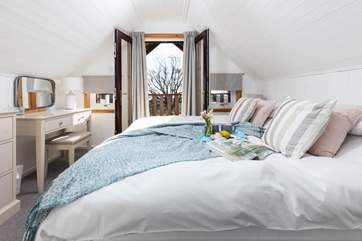 The main bedroom has a super-king bed and patio doors leading on to the deck.