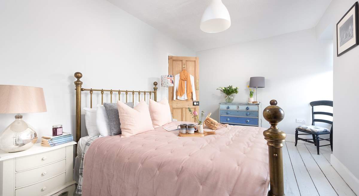 Pretty as a picture, the double bedroom has a dreamy brass bedstead and reclaimed floorboards to add to the charm.